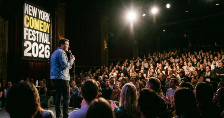 Comedian performing on stage at the New York Comedy Festival 2026 with a packed audience in the background